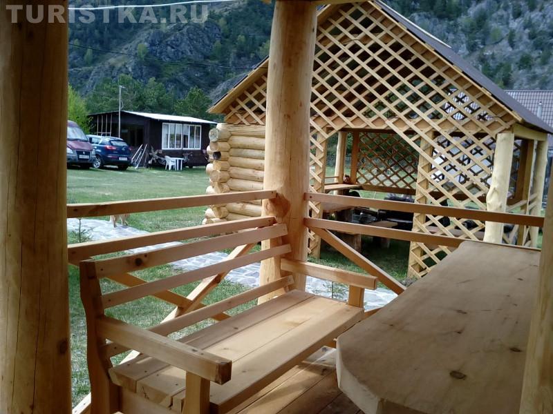 Крыльцо-веранда с деревянной лавкой и столом